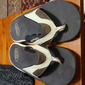 Brown and white Reef thong flip flops.